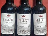 three bottles of red wine are lined up on a red table