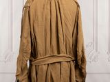 a brown trench coat on a mannequin stand in front of a white wall
