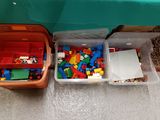 deux bacs remplis de Lego et un ordinateur portable posés par terre