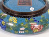 a blue vase with flowers on it sitting on a table