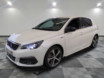 La voiture blanche est garée dans la pièce, sur un sol à carreaux.