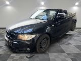 une photo d'une BMW décapotable noire garée sur un sol à damier