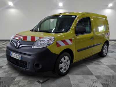 La petite camionnette jaune est garée dans une grande pièce au sol carrelé.