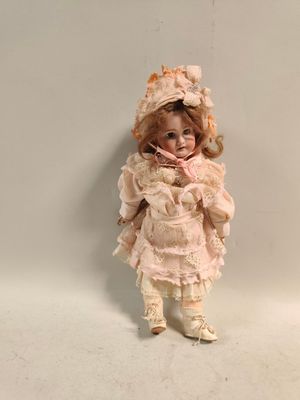 a small doll that is standing up against a wall