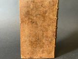 an old book sitting on top of a table next to a gray background