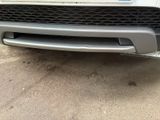 the front end of a white car with a blue license plate on it