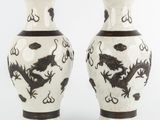 une paire de vases noirs et blancs ornés de motifs de dragons