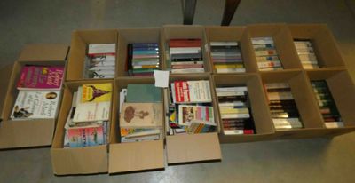 de nombreux livres dans les cartons posés par terre