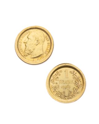 deux pièces d'or posées sur une surface blanche, sur fond blanc