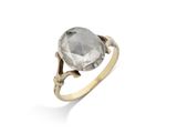 un gros plan d'une bague en or sertie d'un diamant gris facetté