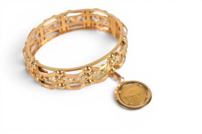 bracelet en or avec une pièce sur fond blanc
