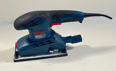 la ponceuse est bleue et noire, avec une poignée rouge