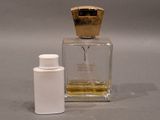 a small bottle of perfume next to a small bottle of perfume