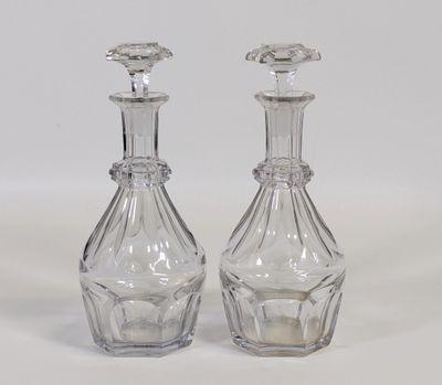 une paire de carafes en verre transparent posées sur une surface blanche