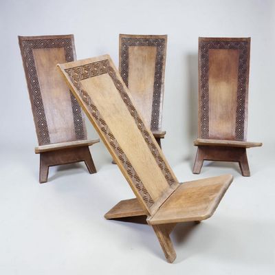 trois chaises en bois ornées de motifs complexes sur fond blanc