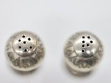 pair of silver salt and pepper shakers on a white surface