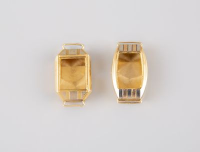une paire de clés USB plaquées or posées sur une surface blanche