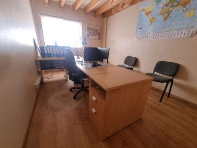 un bureau avec deux ordinateurs et une chaise dans une pièce