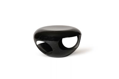 un objet noir posé sur une surface blanche, avec un fond blanc