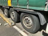 un semi-remorque vert garé sur le bord de la route