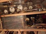 many different types of clocks on display in a glass case