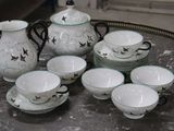a lot of cups and saucers sitting on a table
