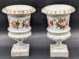 pair of white vases with floral designs on them on a black background