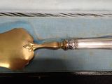 a silver spoon with a gold handle sitting on a blue box