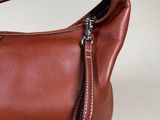 brown leather handbag with zippers on a white background