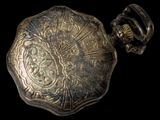 a close up of a pocket watch on a black background