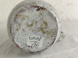 a close up of a white vase with a sticker on it