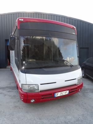un bus rouge et blanc garé devant un immeuble