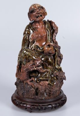 une image représentant la statue d'un homme assis sur un rocher