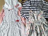 Deux robes sont posées sur une boîte en carton posée par terre.