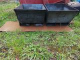 two bins that are sitting on the ground in the grass