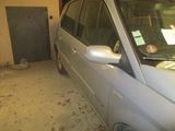 une voiture garée dans un garage à côté d'une poubelle