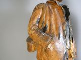 une statue en bois représentant un homme portant un chapeau et un manteau