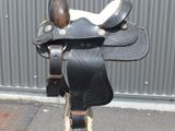 a saddle that is on top of a metal pole