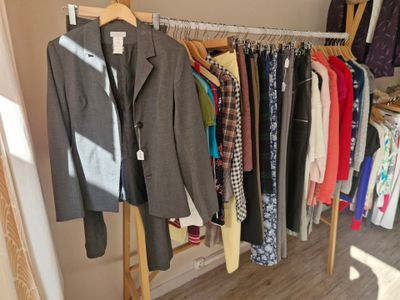 a lot of clothes hanging on a rack in a closet