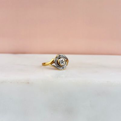 a close up of a gold and diamond ring on a marble surface