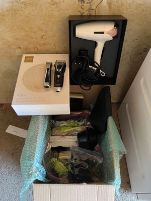 un sèche-cheveux et d'autres objets dans une boîte posée par terre
