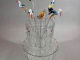 a glass vase with a bunch of birds on top of it