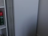 a small white refrigerator in the corner of a room