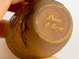 a person holding a small wooden object with writing on it