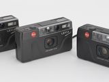 trois petits appareils photo placés les uns à côté des autres sur une surface blanche
