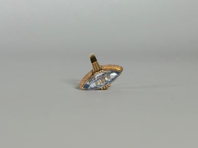 Gros plan sur une bague en or ornée d'une topaze bleue