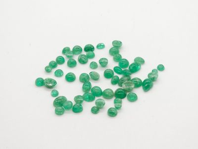 a pile of green glass beads on a white surface