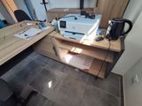 a desk with a printer and a coffee pot on it