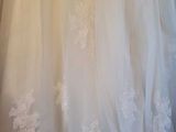 wedding dress hanging on a hanger in a bridal room