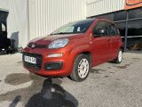 La petite voiture rouge est garée devant un immeuble.